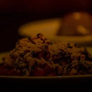 A plate of vegetable stew in low light