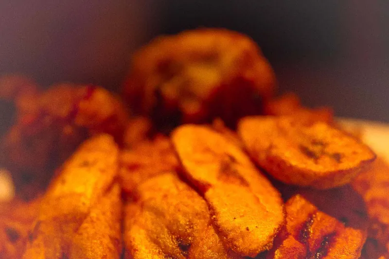 Slices of fried plantain piled on a plate