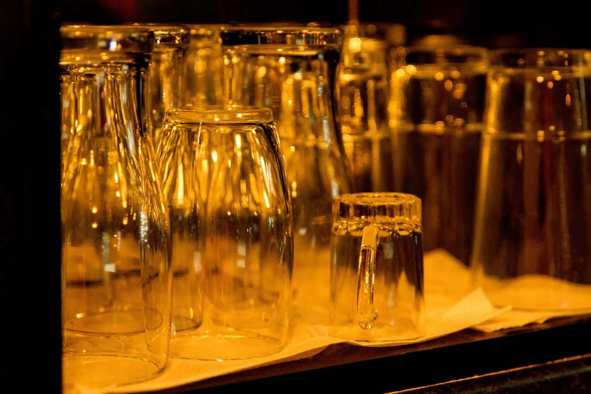 Clean glasses lined up on the bar shelf